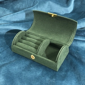 Detail view of the green velvet travel jewelry box with golden buckle and multi-layer slots