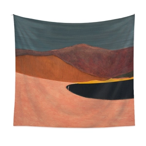 Detail of bohemian tapestry featuring abstract landscape print in earthy burnt orange and blue