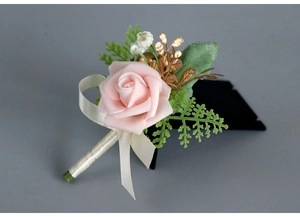 Detail of pink foam rose boutonniere with green fern and gold berry accents