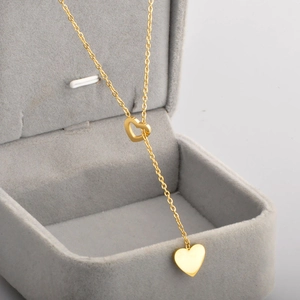 Collana a Y minimalista in acciaio al titanio dorato con pendenti a cuore pieni e vuoti