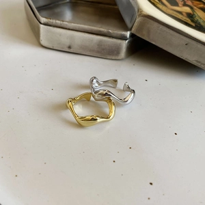 Detailed view of gold and silver minimalist wavy rings with liquid metal texture finish