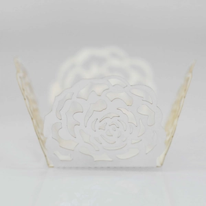 Detailed laser-cut white rose pattern on decorative paper cupcake wrappers for weddings