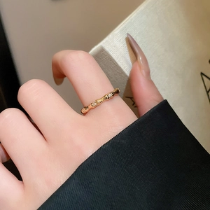 Detailed view of gold bamboo joint ring with sparkling white zircon stones on model hand