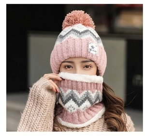Close-up of pink knit winter hat with fleece lining and soft faux fur pom-poms