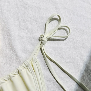 Detail of the high-quality stitching and knotted tie on this cream mesh bikini set