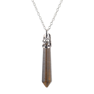 Detail of tiger eye hexagonal stone pendant with ornate silver metal cap on chain