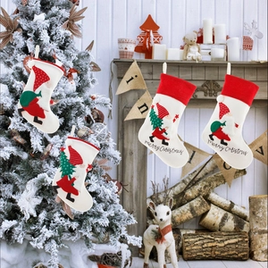 White Nordic Christmas stockings with Santa embroidery hanging by the fireplace
