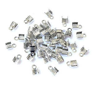 Detailed macro view of bulk silver metal ribbon crimp ends with loop for DIY jewelry making
