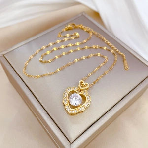 Luxurious gold heart pendant necklace with shimmering zircon on elegant silk background