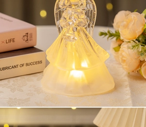 Detail of a glowing crystal-like angel ornament with warm LED light and musical trombone