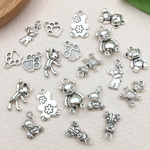 Detailansicht antiker Teddybär- und Fußabdruck-Anhänger aus Silber für DIY-Schmuckstücke
