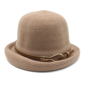 Close-up of camel knitted bucket hat featuring refined texture and brown leather strap