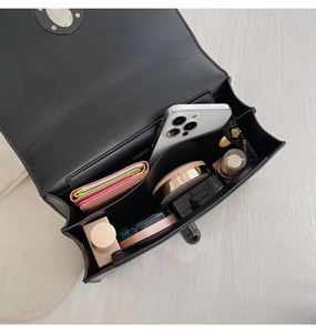 Top view of the interior compartment of a black crossbody bag showing its storage capacity