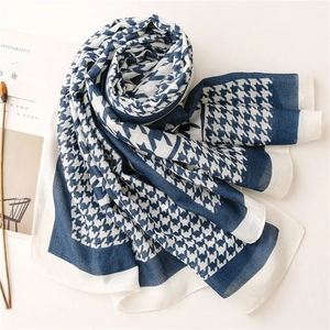 Detail shot of lightweight houndstooth scarf with elegant navy and beige pattern texture