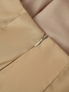 Détail de la texture du tissu tissé beige et de la fermeture éclair invisible assortie