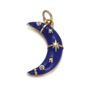 Macro shot of dark blue enamel moon charm with gold edge and zircon stars for jewelry