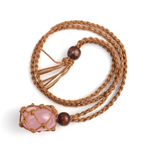 Detail of handmade adjustable brown woven cord necklace with raw pink crystal stone pendant