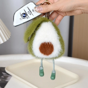 Macro d'un porte-clés avocat en peluche avec fourrure douce et petites bottes vertes