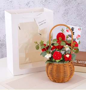 Macro view of handmade crochet strawberry bouquet in a woven basket with gift packaging