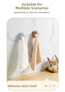 Detail of grey and brown bear-shaped towel hooks holding cloths on a marble wall