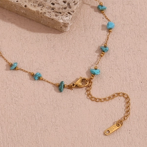 Detail of 18K gold plated stainless steel chain with blue turquoise stones and K18 hallmark