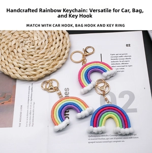 Close-up of three handmade rainbow keychains with colorful cotton rope and white pompoms