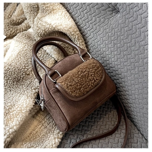 Detail of plush faux shearling and brown suede patchwork on stylish winter handbag