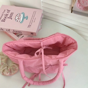 Detail of pink quilted handbag showing interior space with a cute bow ribbon decoration