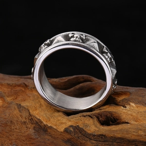 Detailed relief of vintage skull titanium steel ring on rustic wood background