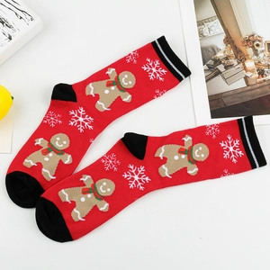 Detail of red Christmas socks featuring gingerbread man patterns and black toe accents