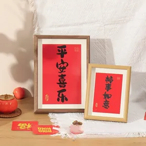 Detail of wooden picture frames with Chinese calligraphy art on lace tablecloth