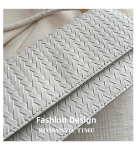 Detailed macro view of premium white woven leather texture on a stylish square bag