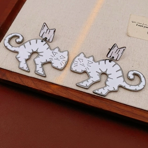 Detailed close-up of cute cartoon crown cat earrings with hand-painted enamel finish
