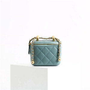 Detailed view of teal quilted leather cosmetic bag with golden ball chain strap adjustment