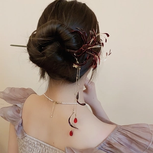 Close-up of a vintage Chinese hair stick with red spider lily and golden tassels