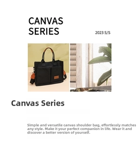 Detail of black canvas tote bag featuring double front pockets and brown leather handles