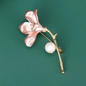 Detail of pink enamel trumpet flower brooch with golden stem and elegant white pearl