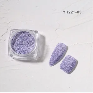 Macro shot of blue-purple nail glitter powder with two finished effect nail tips in a jar