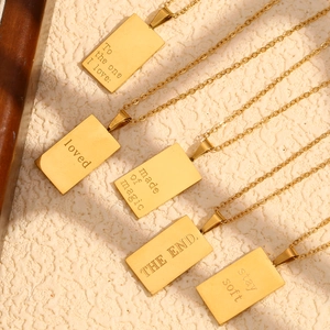 Close-up of five 18K gold plated square pendants with engraved English quotes and phrases