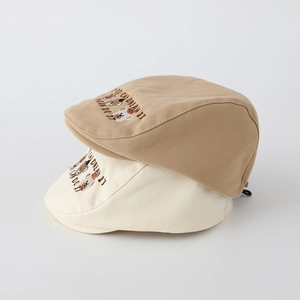 Detail of khaki and beige cotton berets with cute bear embroidery and inspirational text