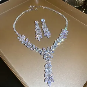 Sparkling zircon leaf tassel necklace and earring set on a luxury golden tray