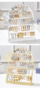 Detail of golden and silver metal earring organizers with 56 holes and elf-shaped design