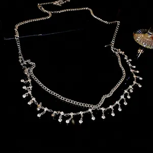Elegant silver double-layer waist chain with sparkling rhinestone tassels on black surface