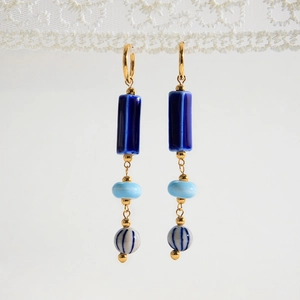 Close-up of retro blue ceramic tassel earrings with gold-plated stainless steel accents