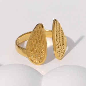 Macro shot of gold wing ring detail showing intricate feather textures and polished finish