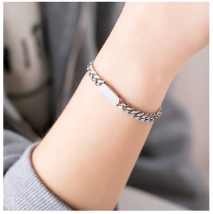 Close-up of a silver titanium steel Cuban chain bracelet with a blank rectangular metal plate
