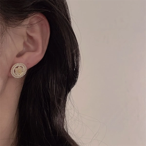 Detail view of retro palace style earring with pearls and pink zircon on model
