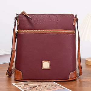 Close-up of wine red litchi texture crossbody bag with gold hardware and brown straps