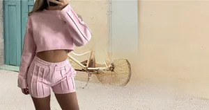Pink two-piece tracksuit set with long sleeve sweatshirt and shorts on a model
