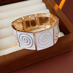 Macro shot of vintage gold squares with white enamel and spiral texture detail
